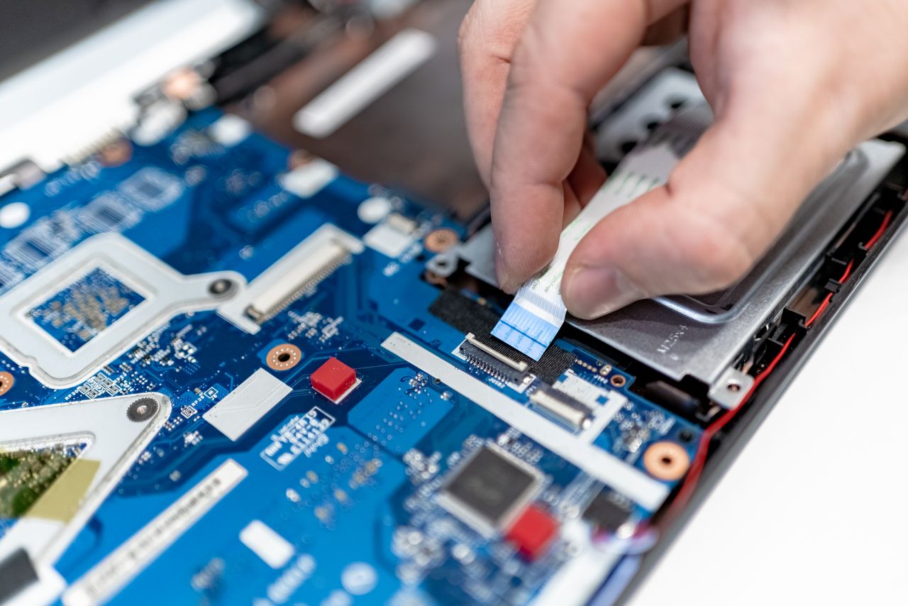 Crafting Captivating Headlines: Your awesome post title goes here Close-up image of hands repairing a laptop circuit board showing intricate details of electronics.